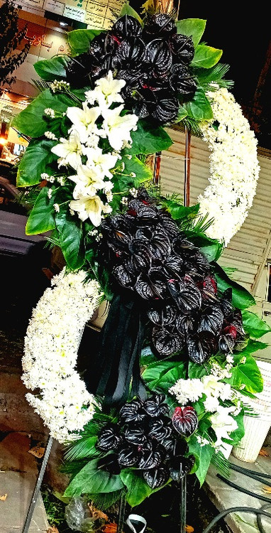 تاج گل ترحیم دوطبقه با طراحی باشکوه از گلفروشی Red Rose با گلهای لیلیوم سفید انتوریوم مشکی داوودی سفید