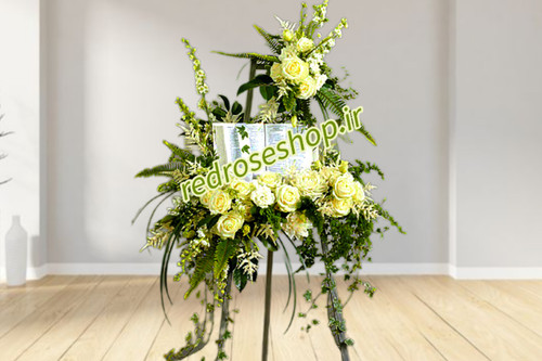 تاج-گل-تبریک-پایه دار-گلهای-سفید-رز-شبو-مریم-برگهای-سبز-تزیینی-پهن-و-ریز